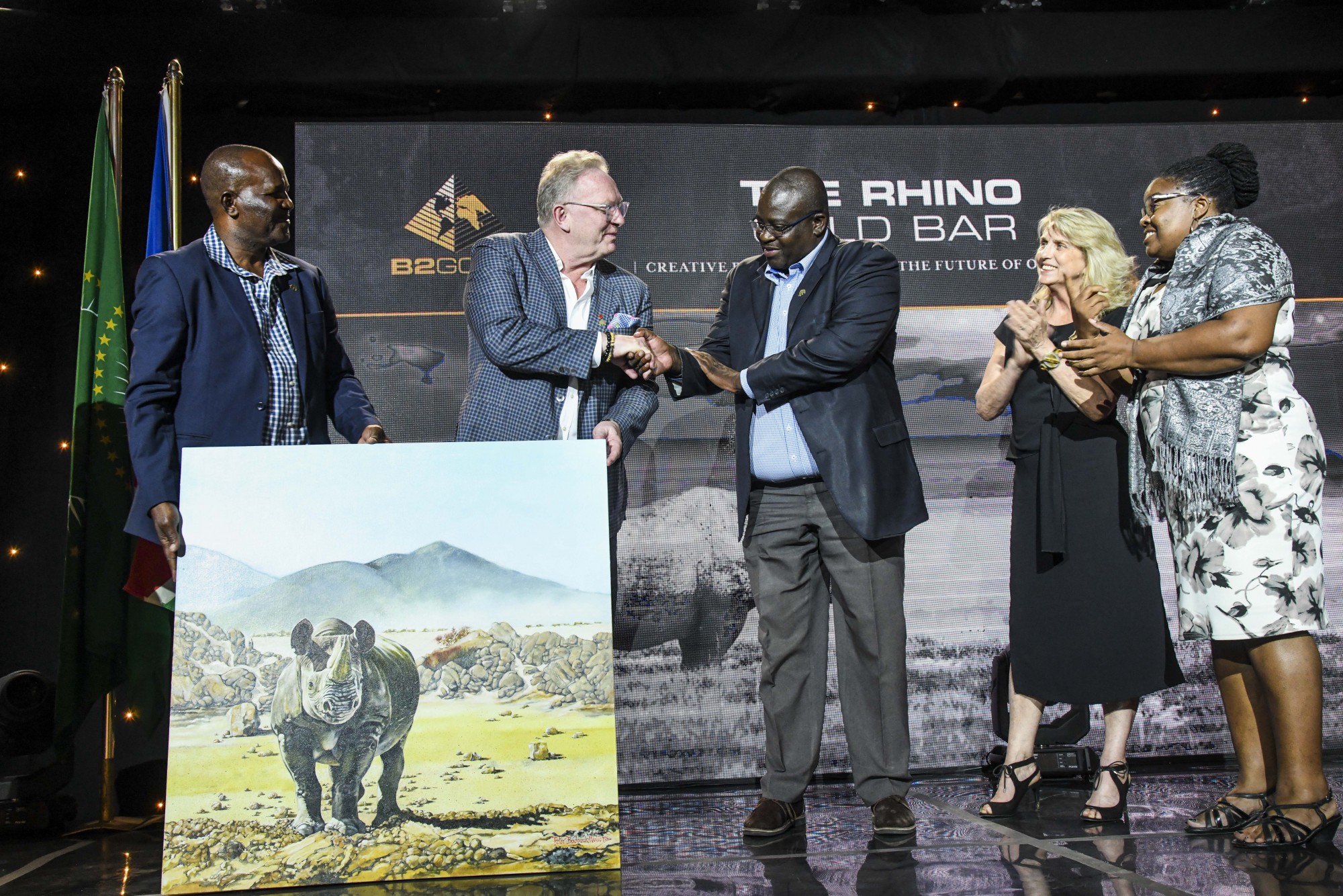 Members from Save the Rhino Trust “SRT” and Integrated Rural Development and Nature Conservation “IRDNC” presenting a token of their appreciation to Clive Johnson (President, CEO & Director, B2Gold Corp.).  From left to right: Simson Uri-Khob (CEO, SRT), Clive Johnson, John Kasaona (Executive Director, IRDNC), Ginger Mauney (Director, SRT) and Maxi Louis (Board of Trustees Chairperson, SRT)