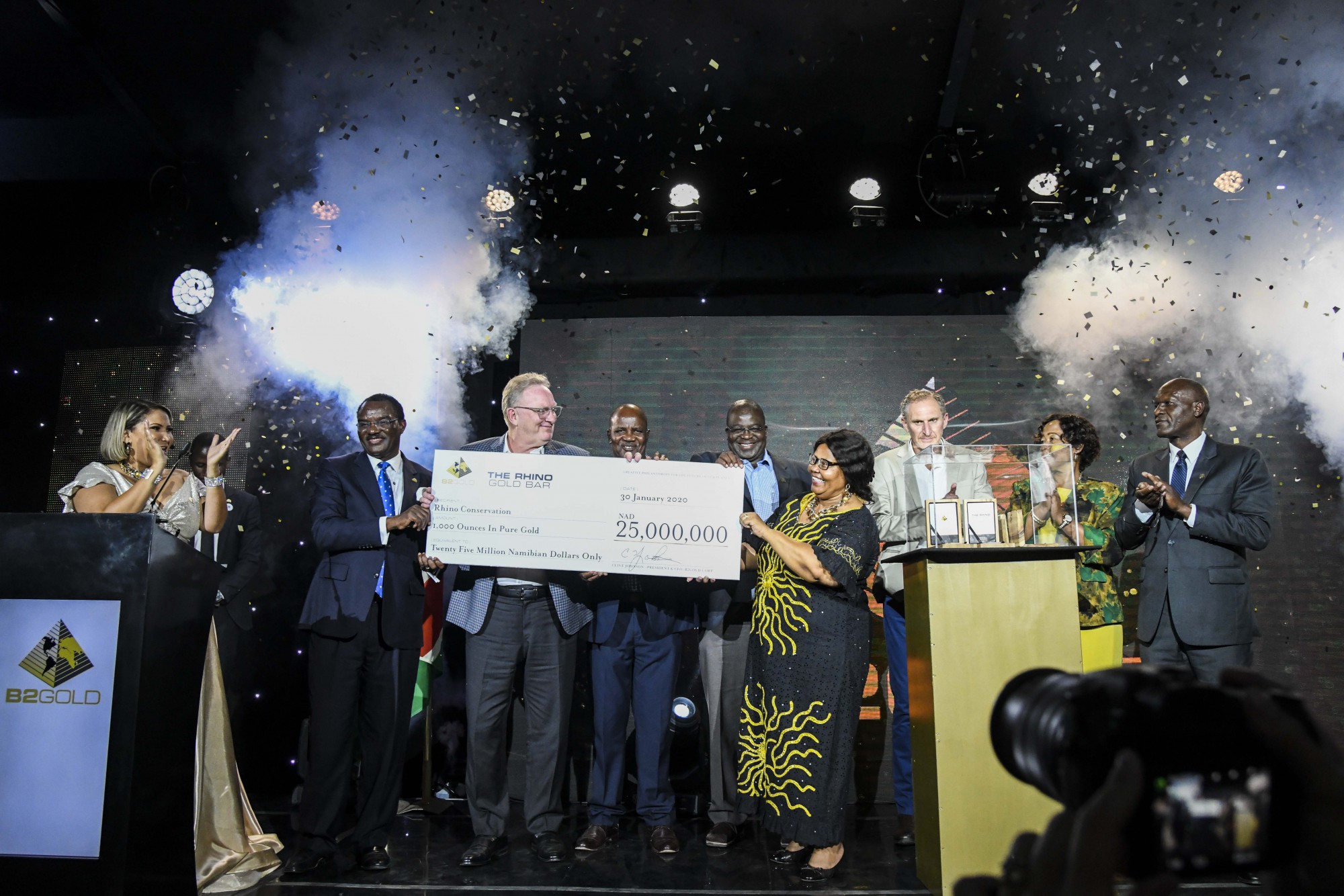 Clive Johnson (President, CEO &amp; Director, B2Gold Corp.) handing a cheque of NAD $25,000,000 (approx. USD $1,500,000)  to various beneficiaries  From left to right: Dr. Leake Hangala ( Director, B2Gold Namibia Proprietary Limited), Clive Johnson, Simson Uri-Khob (CEO, Save the Rhino Trust), John Kasaona (Executive Director, Integrated Rural Development and Nature Conservation), Honorable Bernadette Jagger (Deputy Minister of Environment and Tourism), Mark Dawe (Country Manager and Managing Director &ndash; Namibia, B2Gold Corp.), Inge Zaamwani-Kamwi (Adviser to the President of the Republic of Namibia, Dr Hage Geingob) and Tom Alweendo (Minister of Mines and Energy)